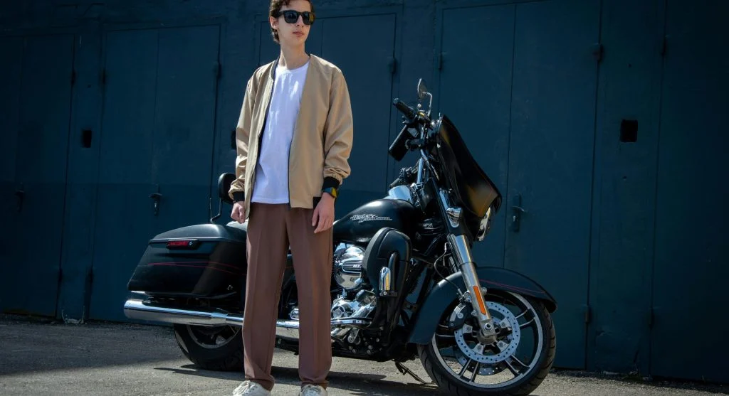 Man wearing light jacket and straight trousers for changing weather
