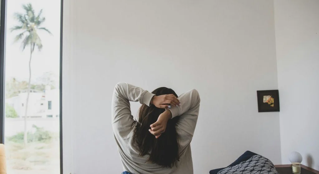 Person meditating in the morning with a cup of coffee