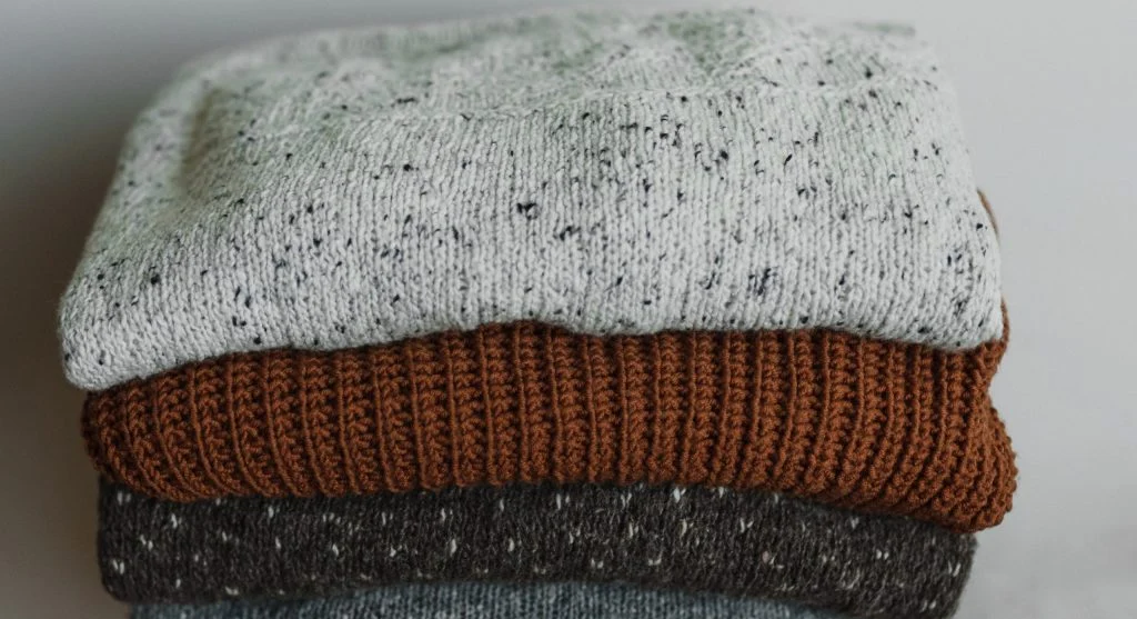 Weather-ready layer options arranged beside simple wardrobe basics for seasonal dressing